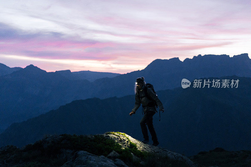 日出时，女徒步旅行者穿过山脊