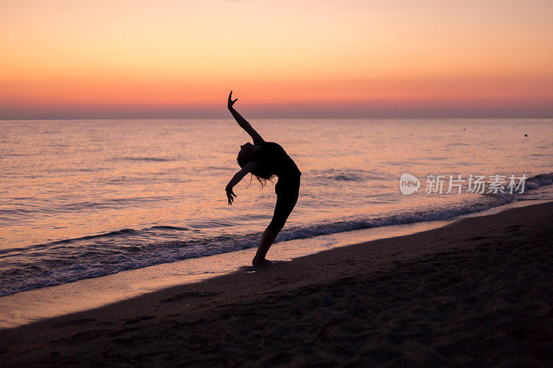 日落时分，女孩在海滩上跳舞
