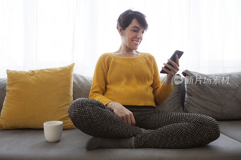 年轻女子在家里使用智能手机