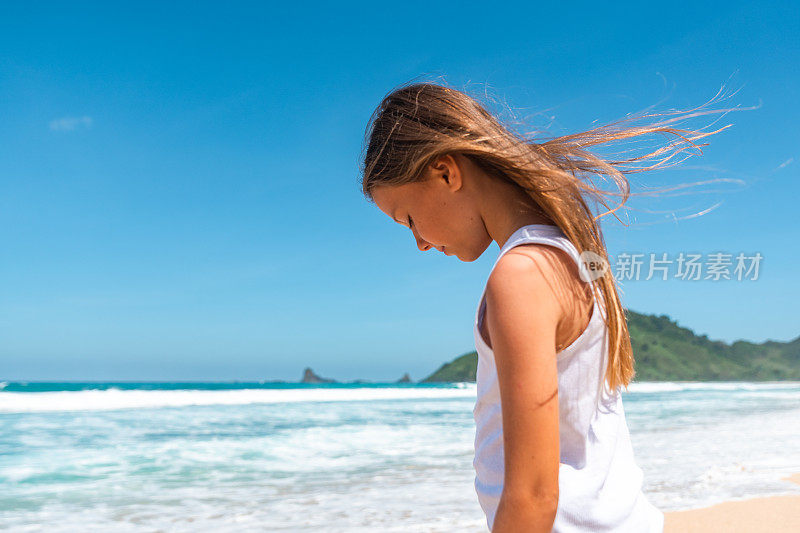 年轻女孩站在一个美丽的热带海滩龙目岛，印度尼西亚库存照片