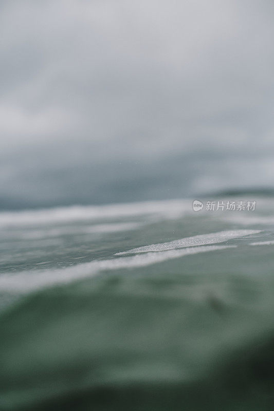 浅浅的焦点海面对抗阴沉沉的秋天天空，纽基，康沃尔。