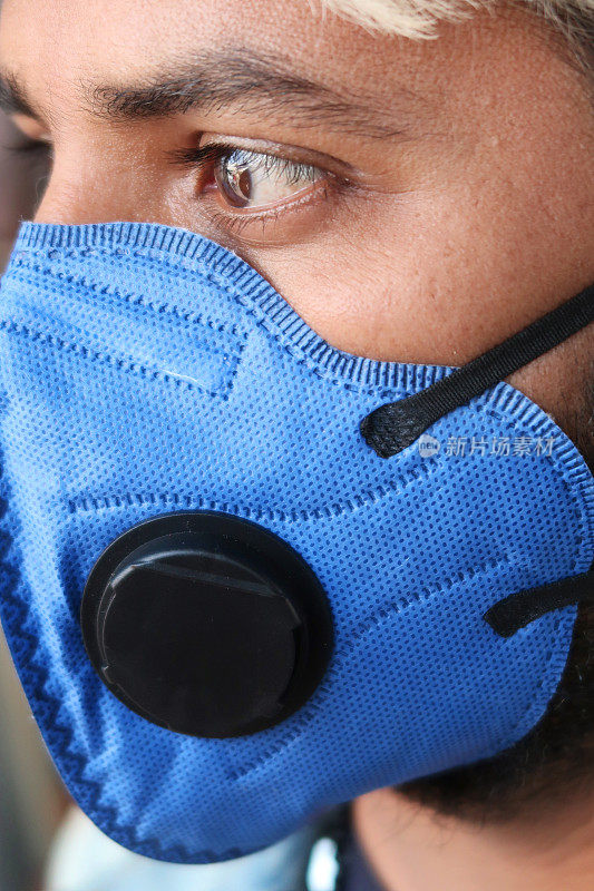 在公共汽车上，印度亚裔男子戴着医用口罩以保护冠状病毒、污染、在全球卫生紧急事件、禽流感、呼吸道问题、病毒性肺炎、SARS、疾病、检疫和疾病期间旅行的口罩