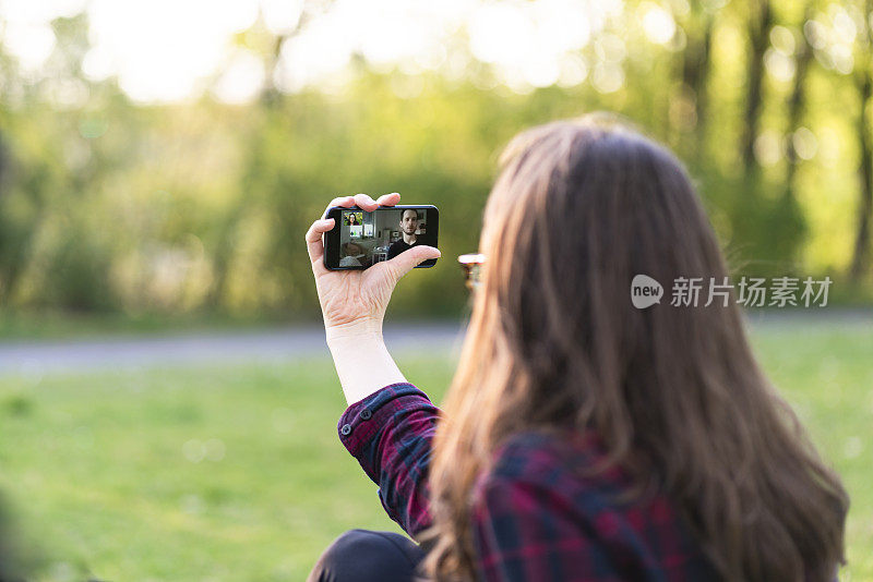 有个女人在公园里视频打电话