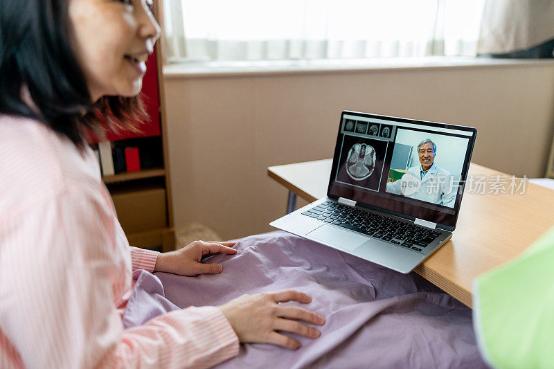 远程保健和访问护理-妇女在家里的笔记本电脑上与医生视频聊天