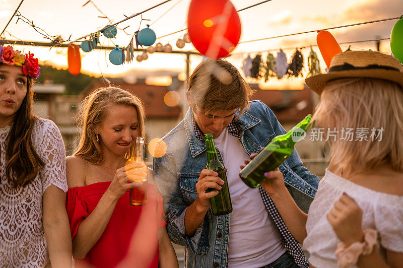 一群年轻人在一个屋顶聚会上玩日落