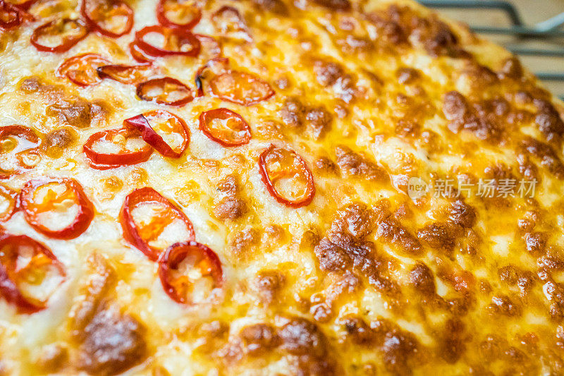 近距离的图像，新鲜出炉的披萨与红辣椒