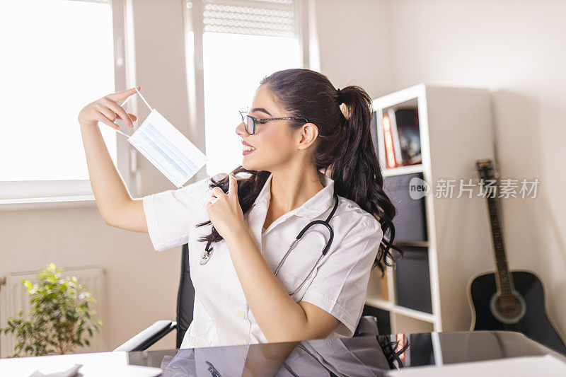 在冠状病毒大流行期间，微笑的女医生在数字平板电脑上与患者视频通话