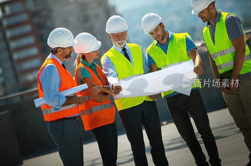 在屋顶监督建筑过程的承包商。