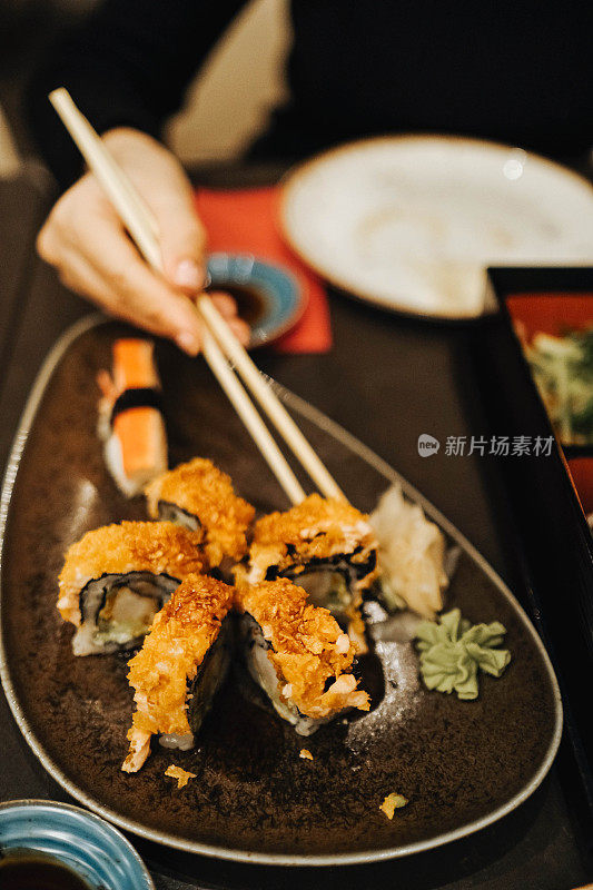 用筷子夹起一块寿司