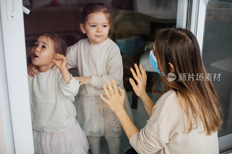 一个女儿通过窗户探望被隔离的母亲，防止她感染冠状病毒