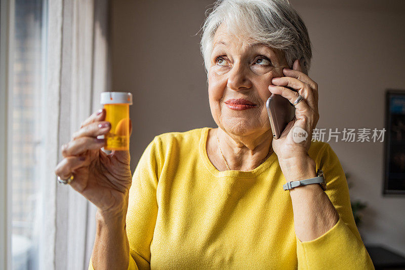 一位年长的女士拿着药瓶和医生通电话