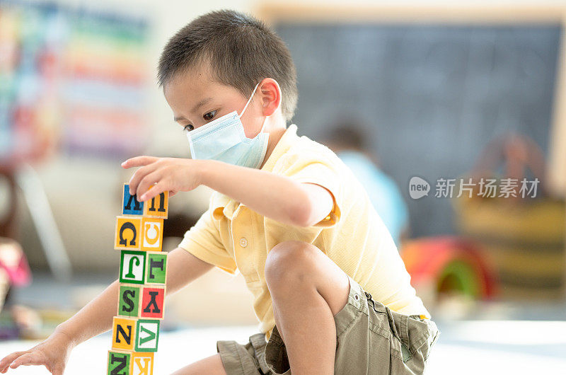 幼儿园男孩戴着面具在教室里的照片