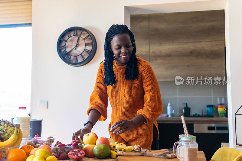 一张非洲裔妇女在家做健康奶昔的照片。提高免疫系统