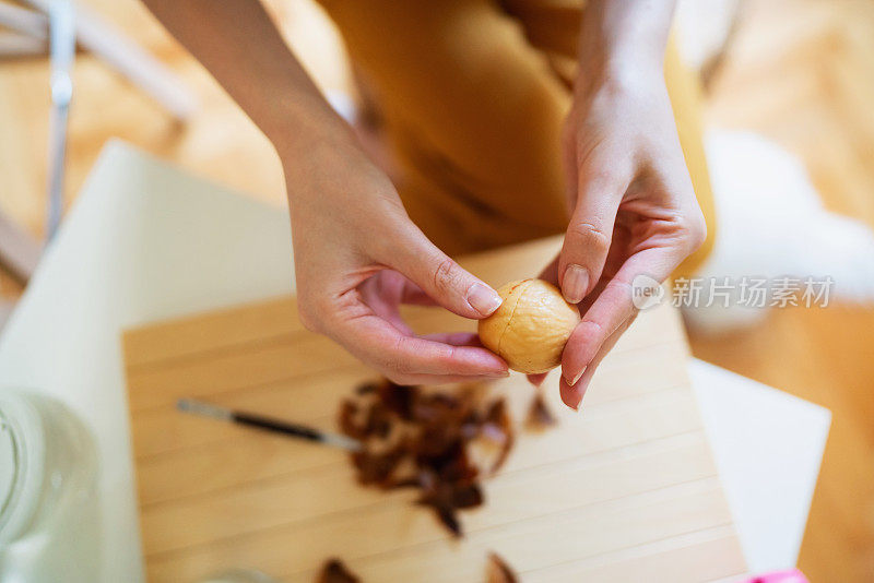 一个不认识的女人的特写镜头拿着一个去皮的牛油果种子在她的手中