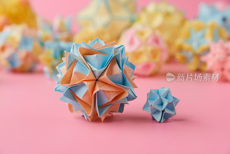 Set的multicolorÂ手工制作modularÂ折纸球或Kusudama孤立在粉红色的背景。视觉艺术，几何学，折纸艺术，纸工艺品。特写，选择性聚焦，复制空间。