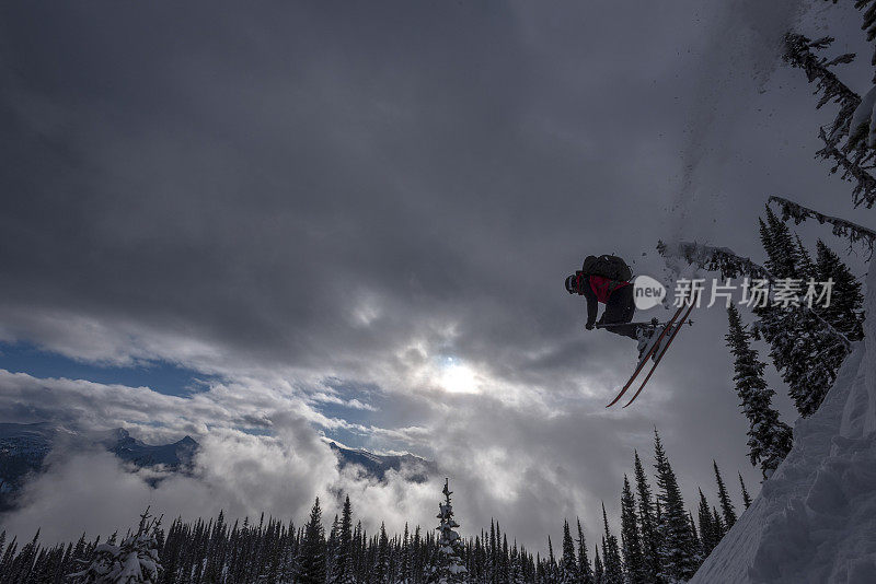 偏远地区的滑雪者从雪山山脊上滑下来