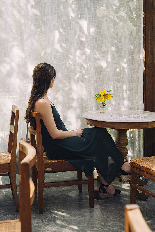 一个陌生的年轻女子独自坐在咖啡店里