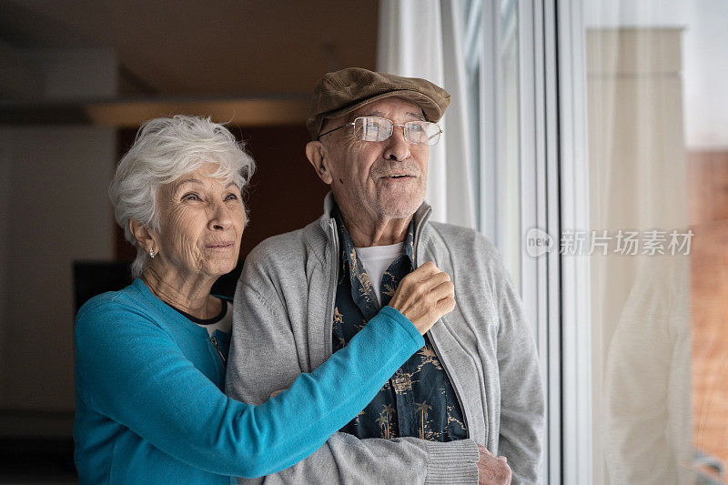 老夫妇望着窗外，在家里沉思
