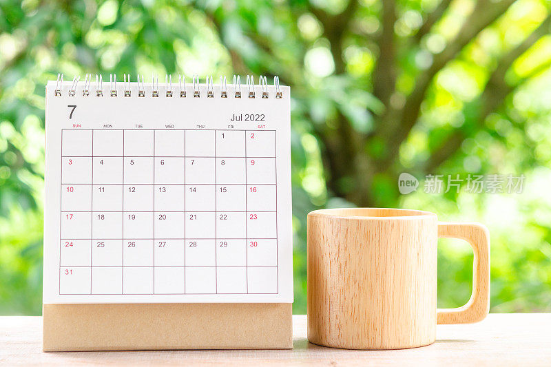 2022年7月，以绿色自然为背景的木桌日历，供主办方规划和提醒。