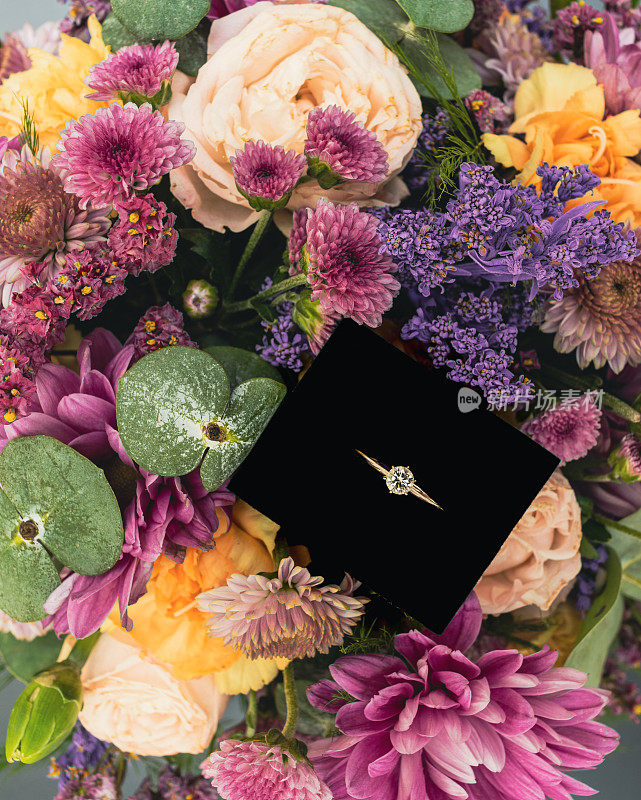 珠宝盒里的结婚戒指放在花头上。