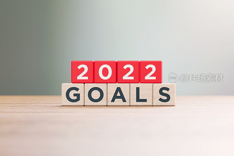 “2022目标”写的红色木块坐在木表面前的散焦背景
