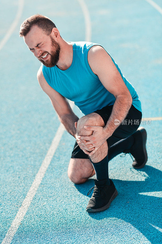 男运动员在跑道上跑步时膝盖疼痛