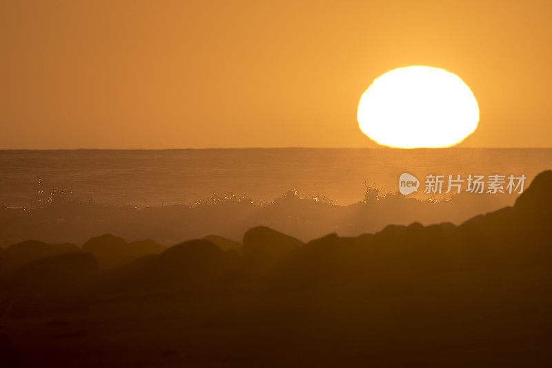 在林孔海滩，日落时海浪拍打着。