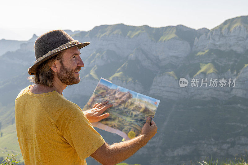 男徒步旅行者在瑞士阿尔卑斯山读步道地图，人们户外活动夏天的概念
