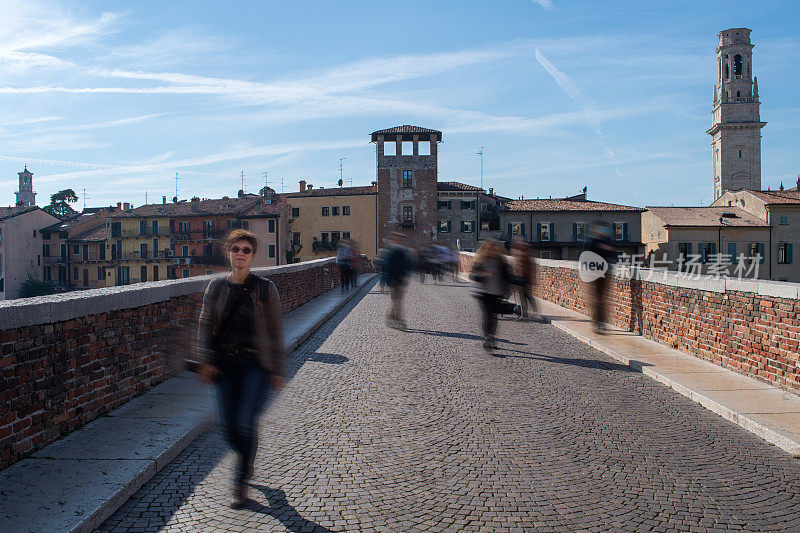 在意大利的维罗纳，一个女人走过一座古老的桥