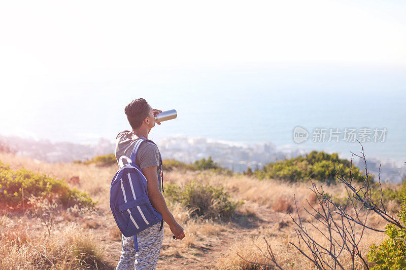 一名年轻男子在南非开普敦的信号山上徒步旅行。