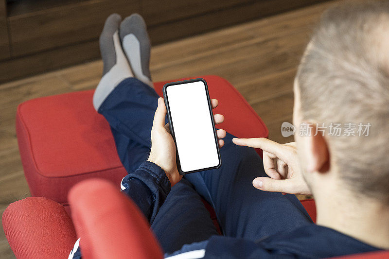 年轻人坐在家里用智能手机。