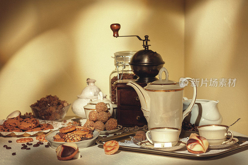 咖啡静物与糖果，饼干，研磨机和两杯咖啡