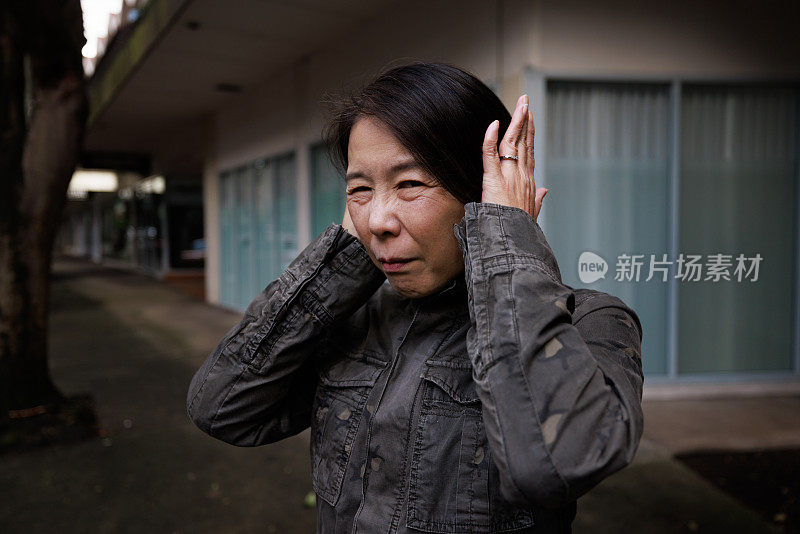 女人捂住耳朵。