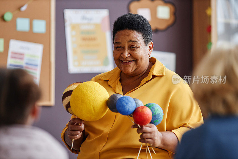 快乐成熟的非裔美国教师与行星模型