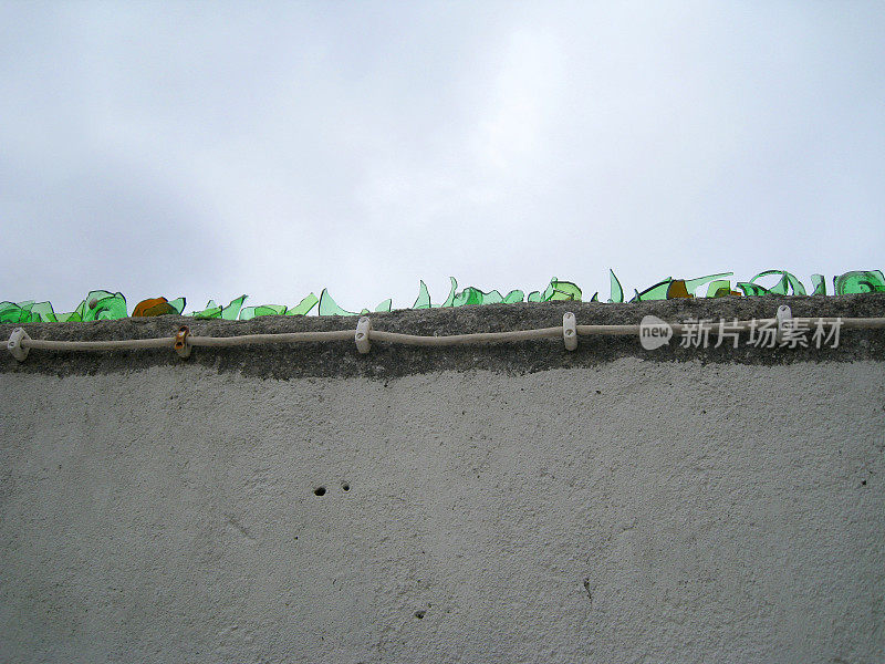 上沿砖墙上玻璃瓶的锋利碎片