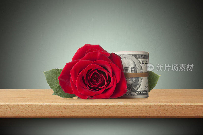 爱和金钱。货架上有红玫瑰和一卷美元钞票。
