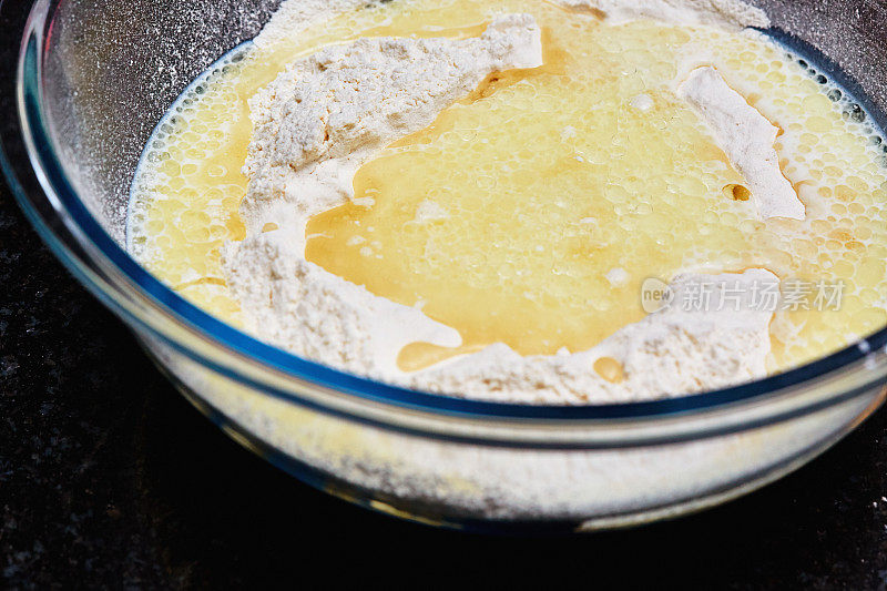 面团制作:玻璃碗里盛有面粉、鸡蛋、油和牛奶