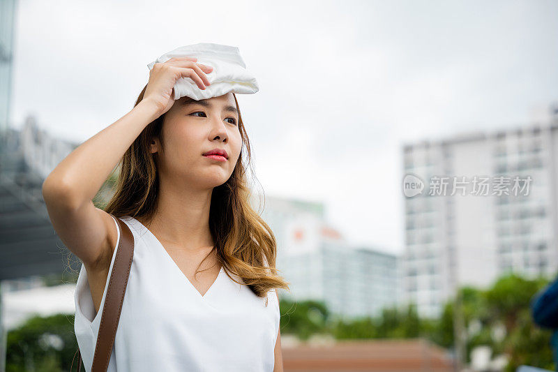 亚洲美丽的女商人在炎热的夏天用布擦干脸上的汗水