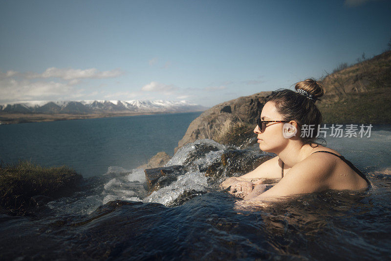 可爱的女人喜欢在室外的温泉游泳，欣赏壮丽的自然风光，阿库雷里。冰岛