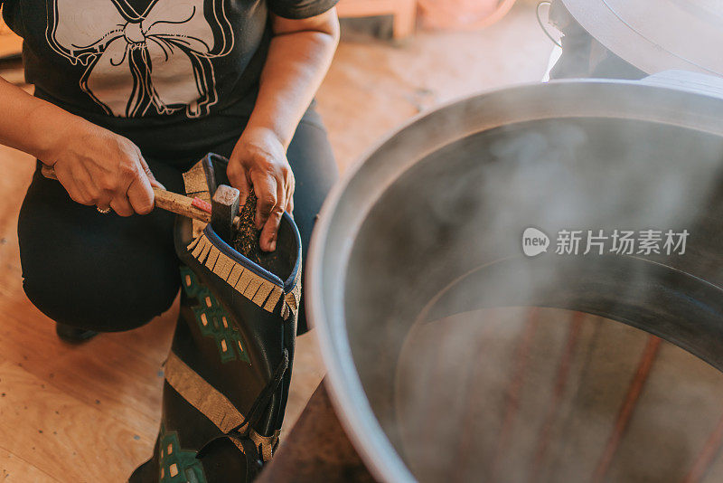 蒙古包内蒙古族牧民妇女为客人准备奶茶