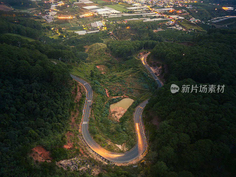 晚霞中的越南大叻市塔农山口鸟瞰图。远处蜿蜒的道路是越南的大叻市