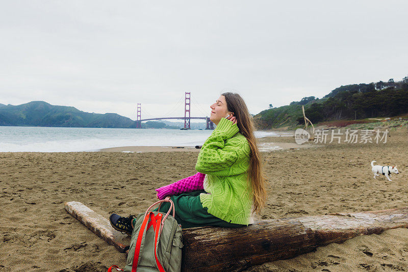 快乐的女人在旧金山的贝克海滩欣赏音乐