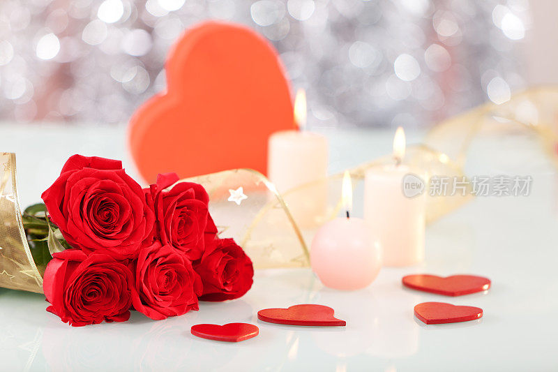 红玫瑰，心形礼盒，蜡烛和丝带