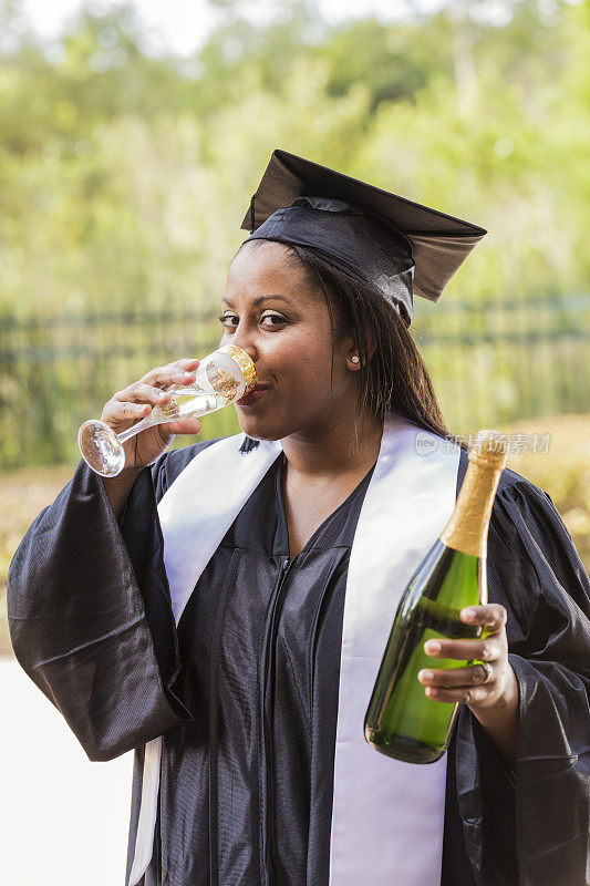 黑人女性成年学生用香槟庆祝毕业