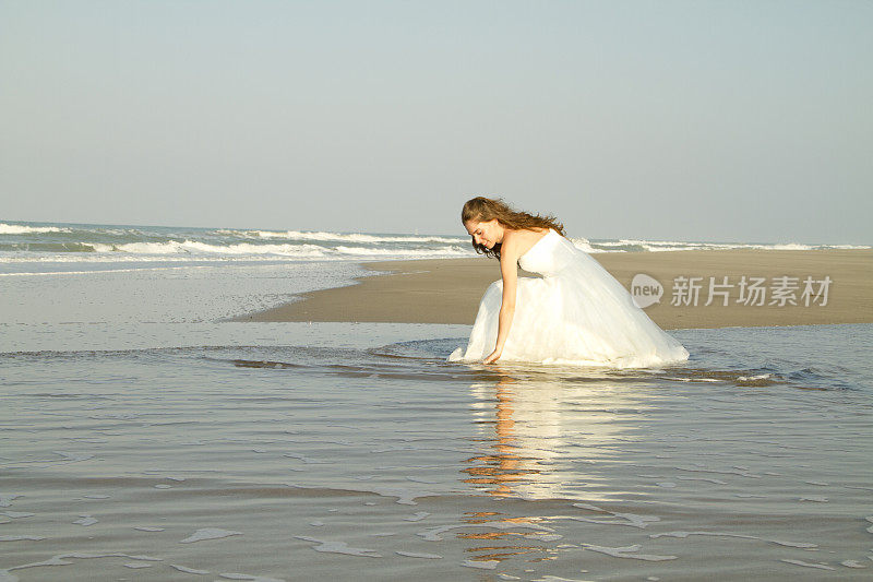 新娘坐在海滩上