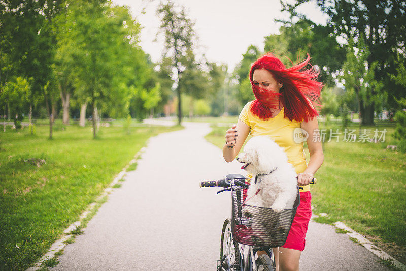 快乐的嬉皮士女孩和她的狗和自行车