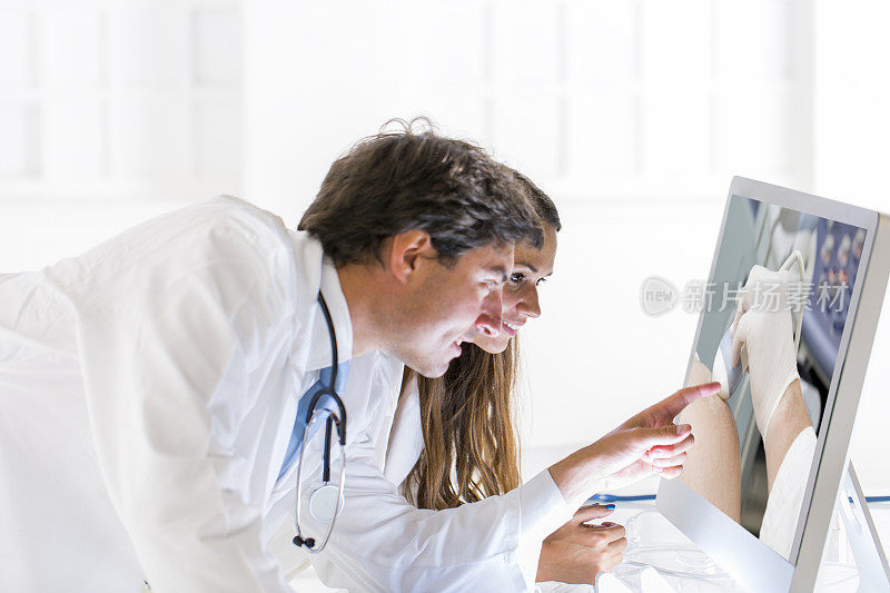 一对年轻的医生在看超声波照片…孕妇
