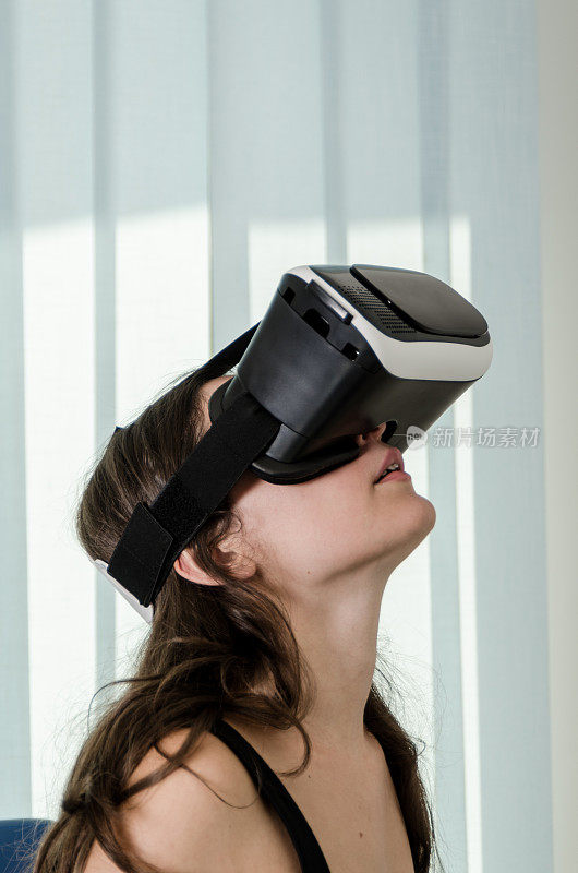 女孩玩虚拟现实模拟器耳机