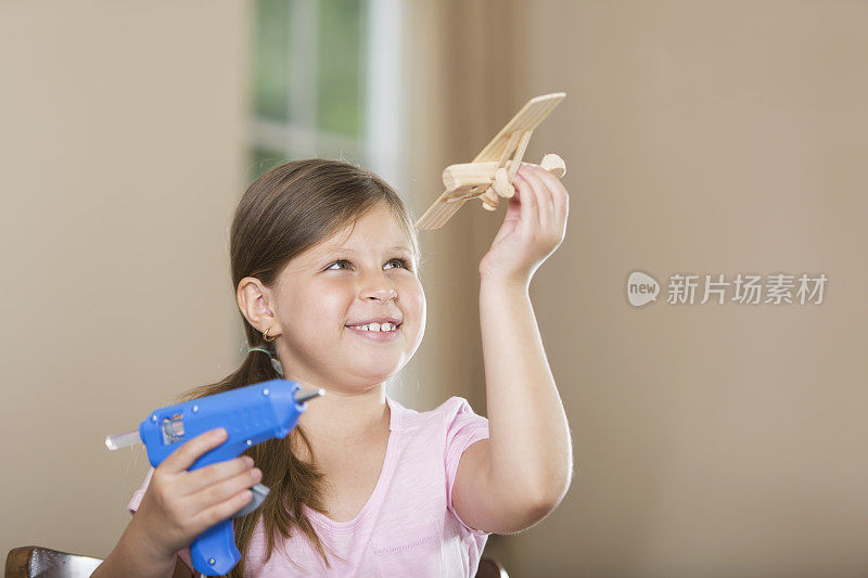 西班牙小女孩在玩玩具飞机模型