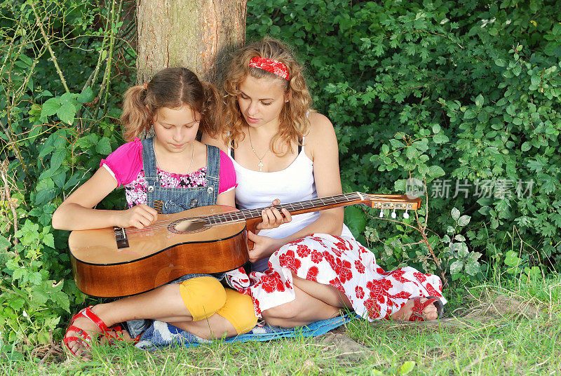 两个女孩在学弹吉他